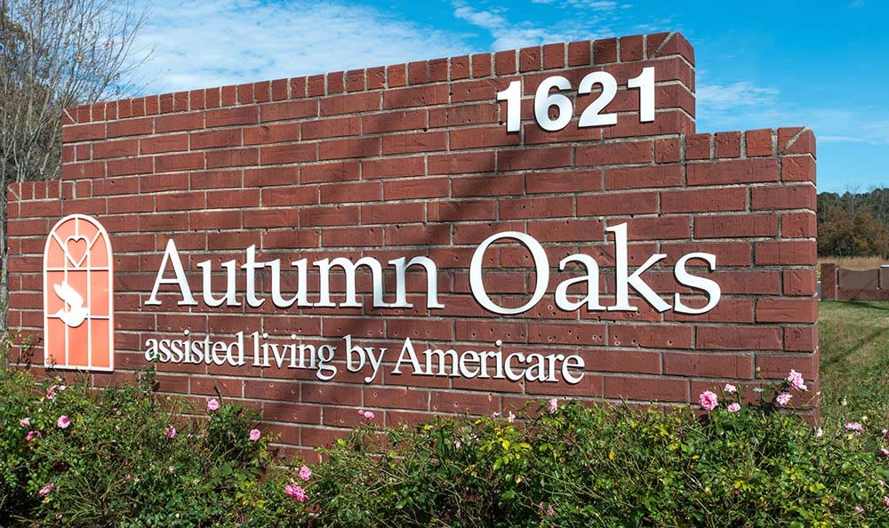 A brick sign for Autumn Oaks, an assisted living facility by Americare, featuring the number 1621.