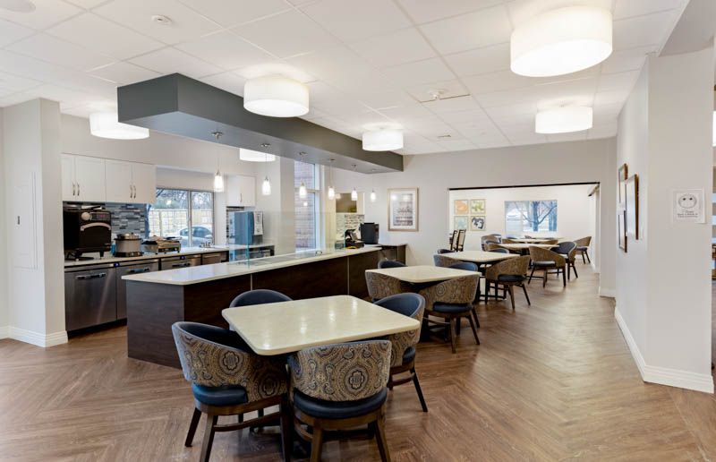 A modern dining area featuring neatly arranged tables and chairs, enhanced by stylish lighting.