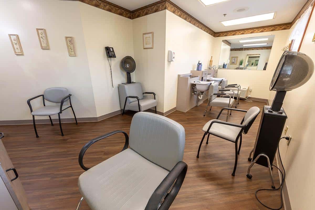 A well-organized waiting room in a medical office with several chairs and a reception desk.