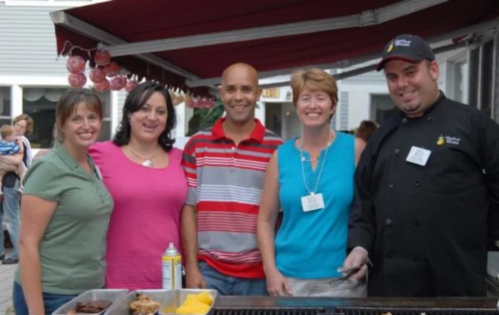 A group of people smiling at a casual outdoor event.