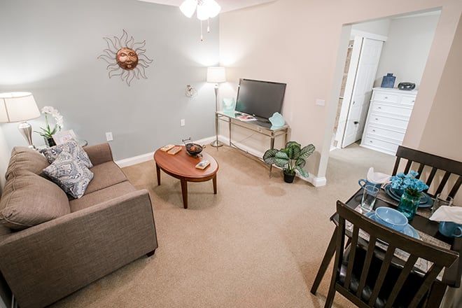 A cozy living room with a sofa, coffee table, television, and stylish decor.
