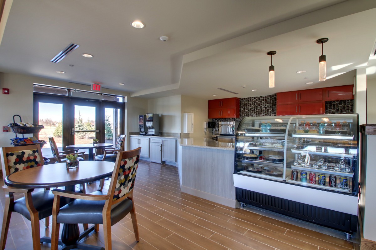 A modern cafe interior with tables and a display case.