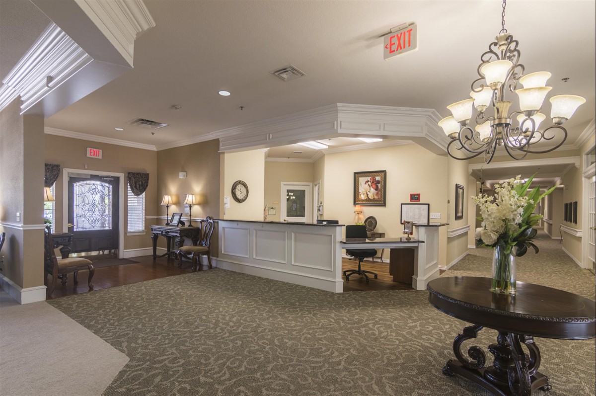 A welcoming reception area with a front desk, decorative lighting, and comfortable seating.