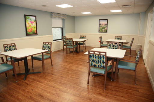 A spacious dining area featuring tables and chairs, complemented by framed artwork on the walls.