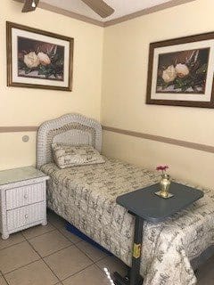 A small bedroom with a single bed, nightstand, and floral-themed decor.