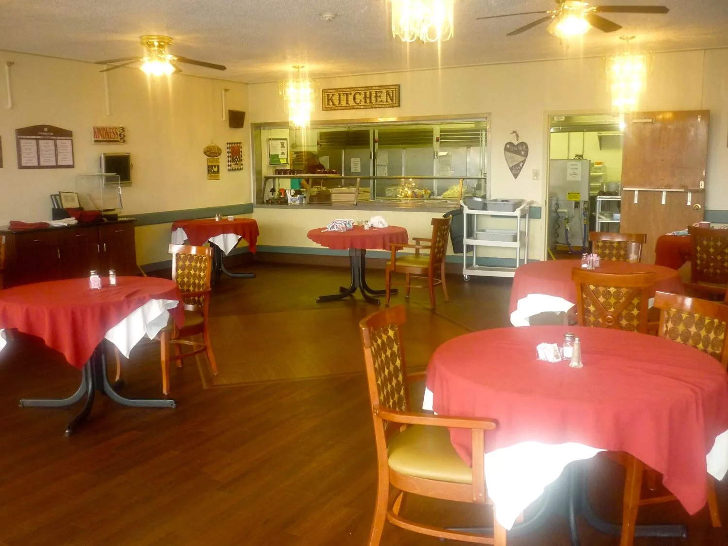 An empty restaurant dining area with tables and chairs neatly arranged.