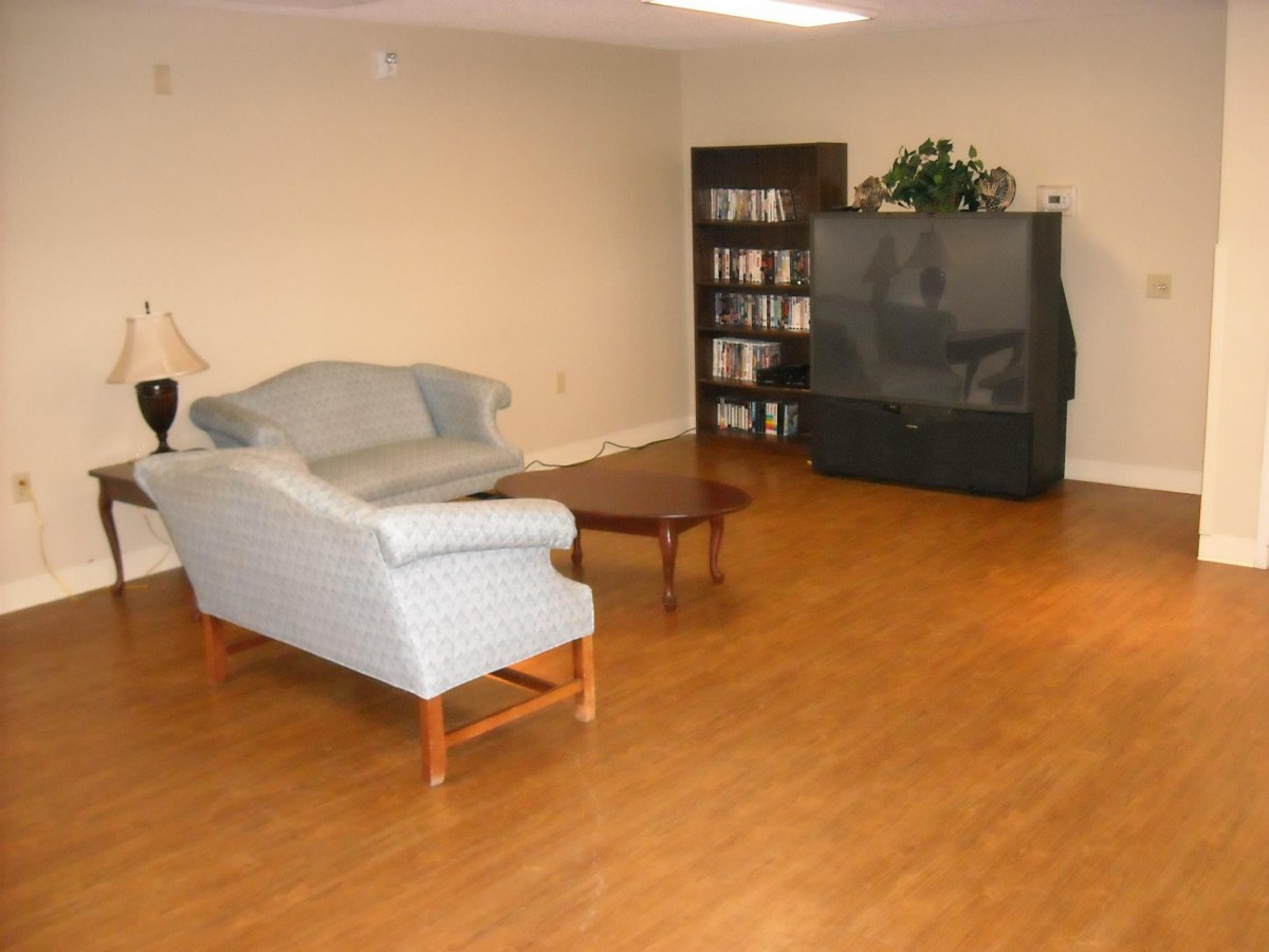 A simple living room setup with a sofa, coffee table, and television.