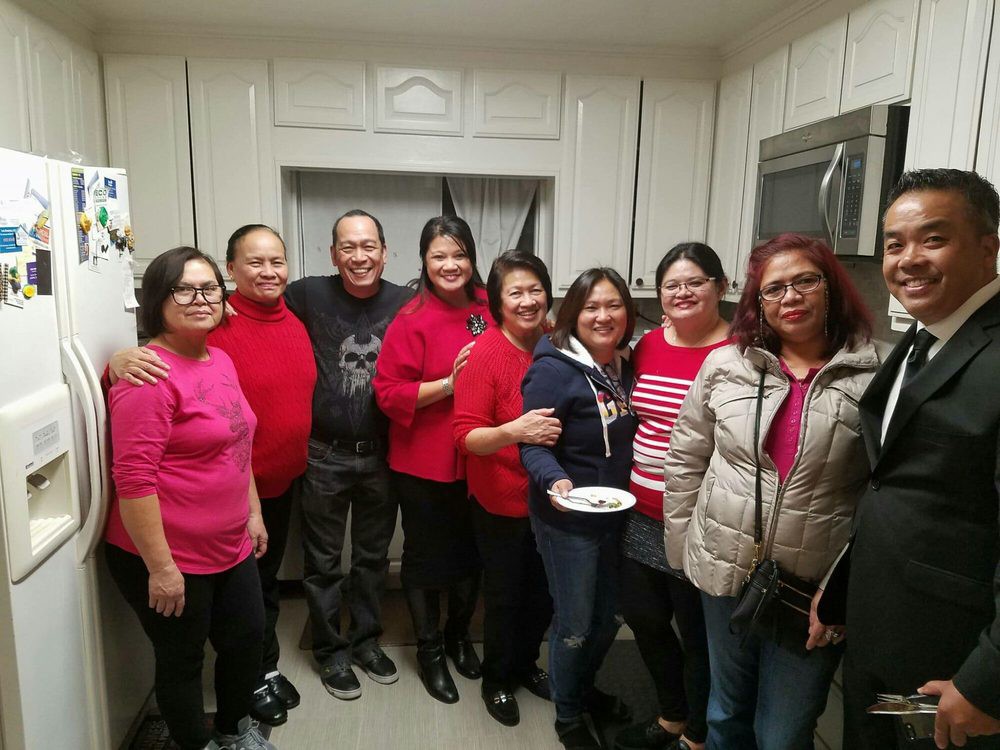 A group of people smiling together in a kitchen.