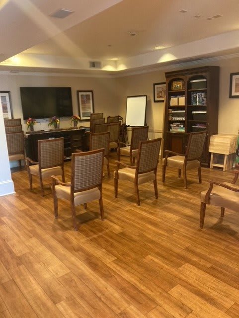 A conference room setup with chairs arranged in a circle, featuring a screen and a whiteboard.