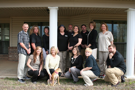 A cheerful team gathers outside for a group photo, showcasing camaraderie and teamwork.