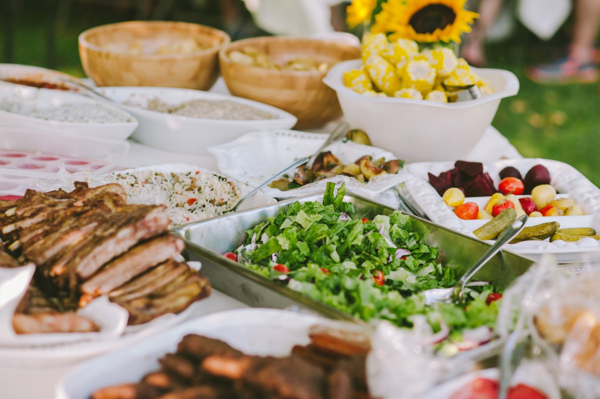 A diverse buffet spread featuring a variety of dishes including salads, meats, and sides.