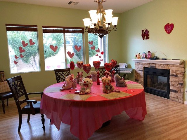 A dining room decorated for Valentine's Day with heart-themed decorations and a festive table setting.
