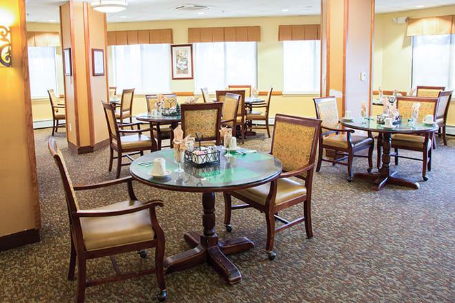 A well-lit dining area with multiple tables and chairs arranged for guests.