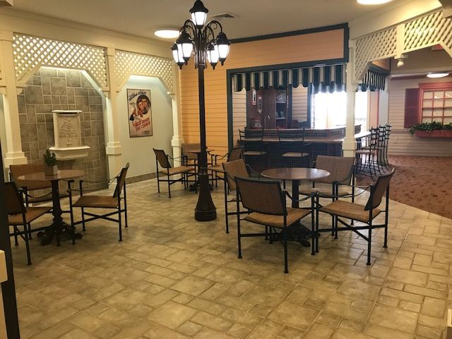An empty cafe with decorative lighting and arranged tables and chairs.