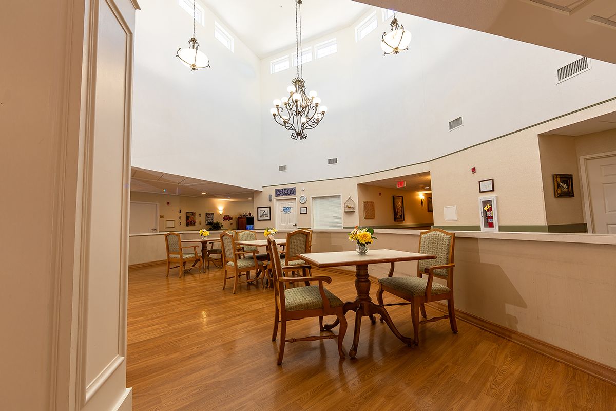 A spacious dining area with chandeliers and wooden flooring.