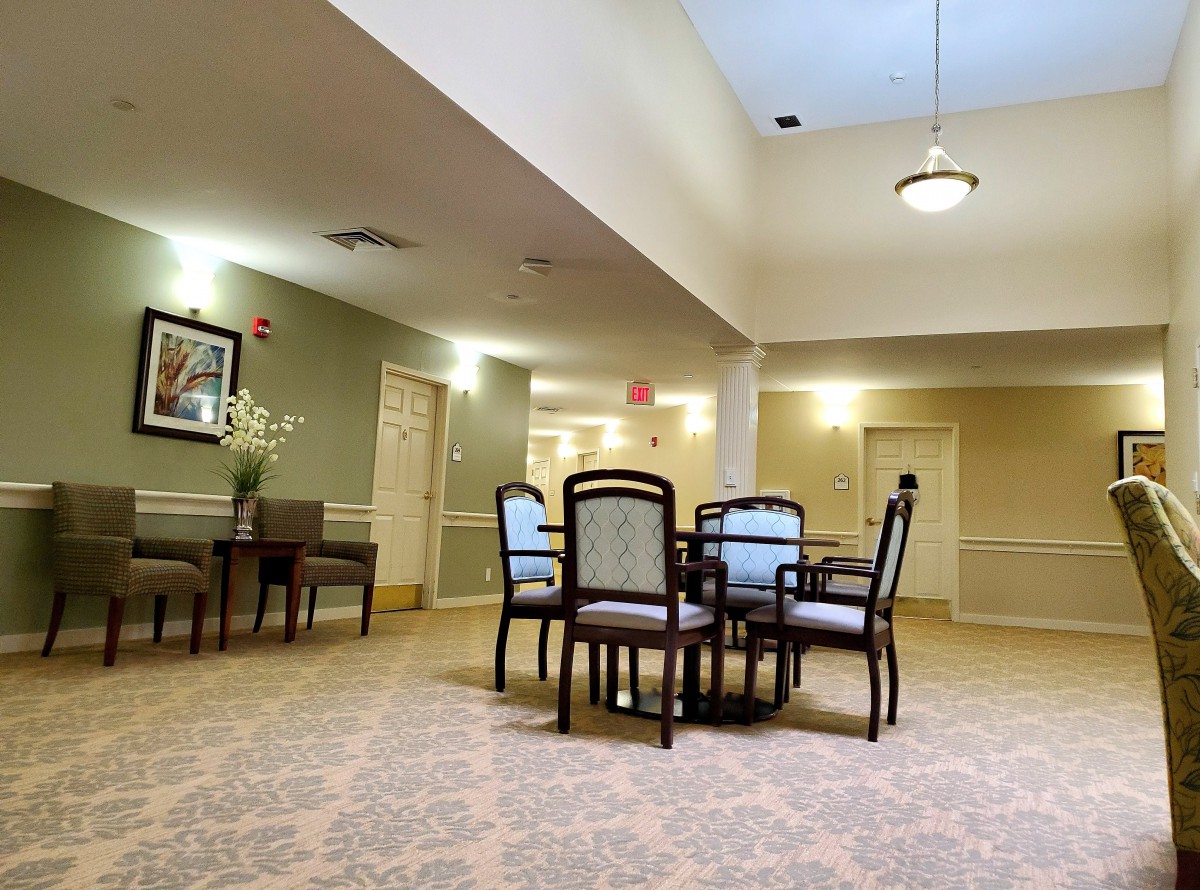 A cozy, well-lit room with a table and chairs, featuring tasteful decor and carpeting.