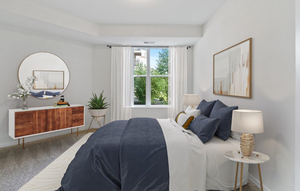 A modern bedroom with stylish decor, featuring a large bed and abundant natural light.
