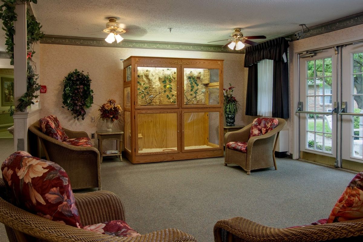 A cozy living room with comfortable seating and a large aquarium.