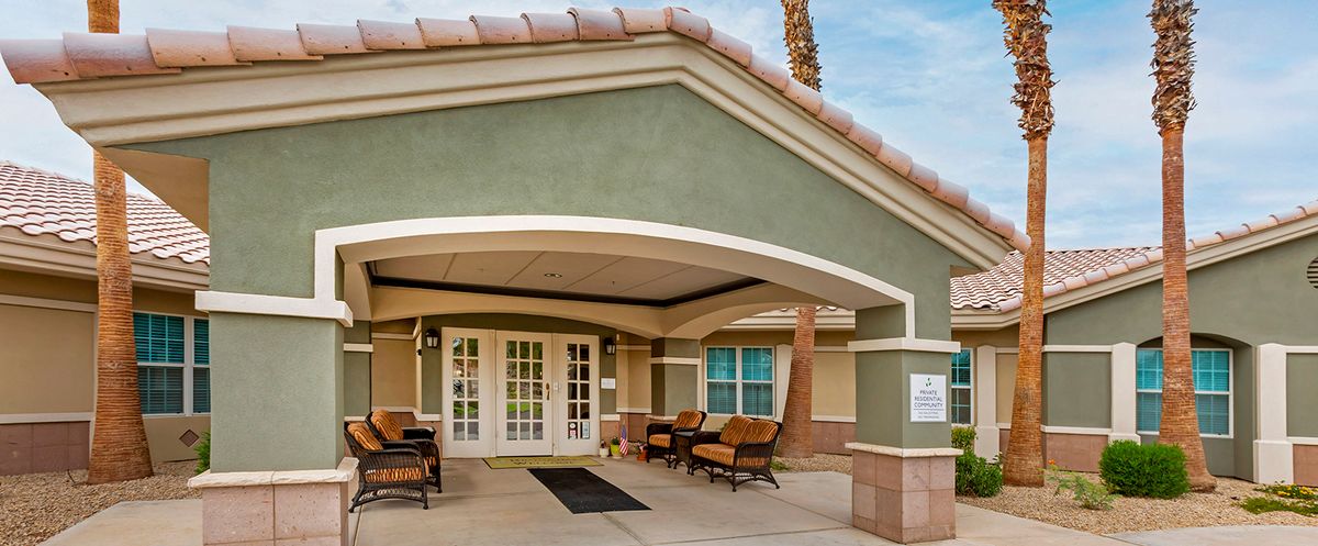 A modern building entrance with patio seating.