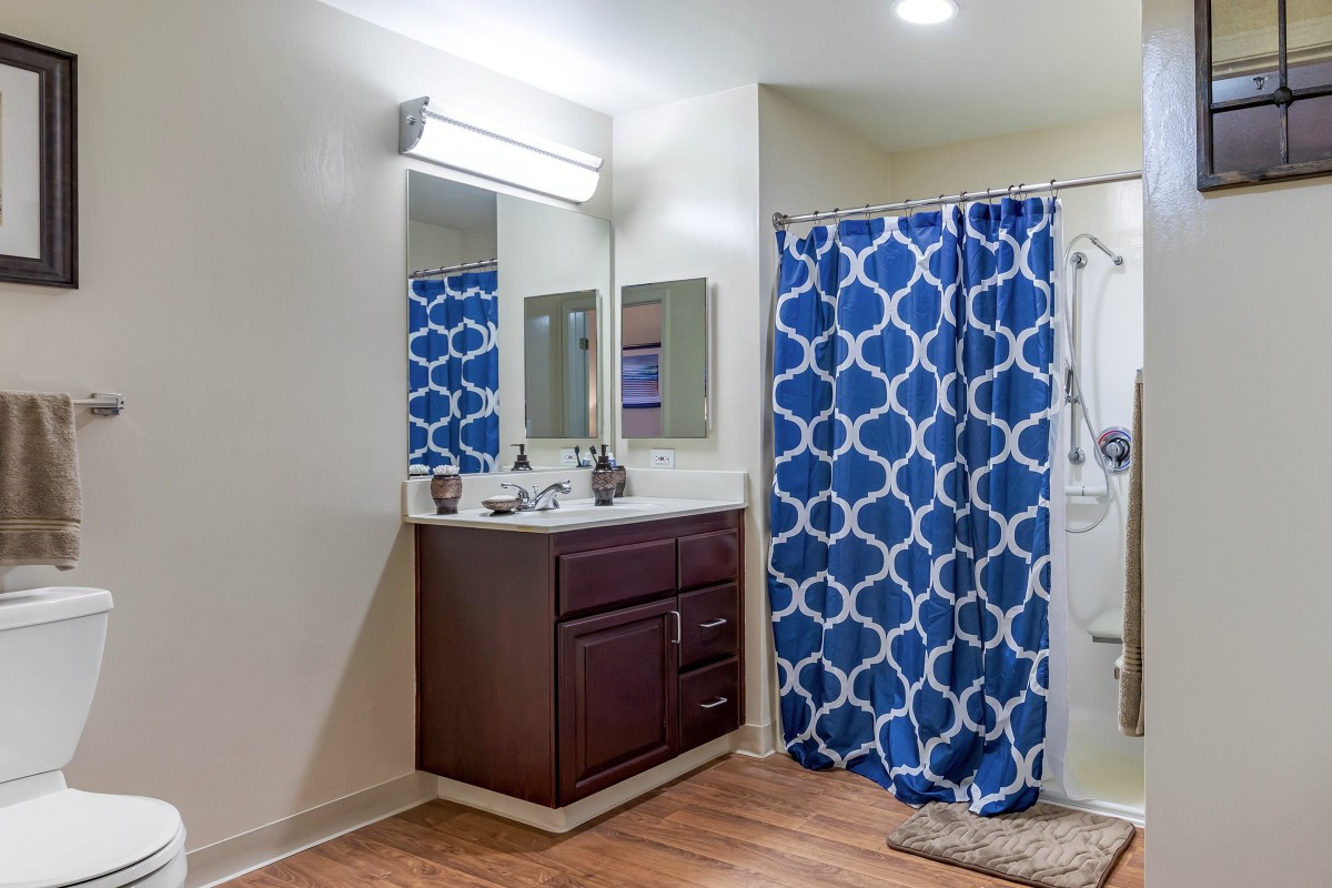 Modern bathroom with a vanity and a blue patterned shower curtain.