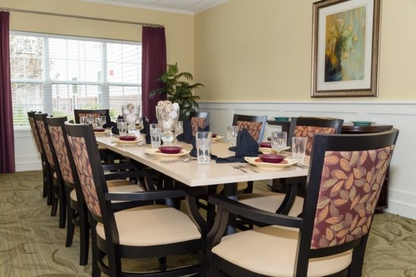 A well-decorated dining room with a large table set for a meal.