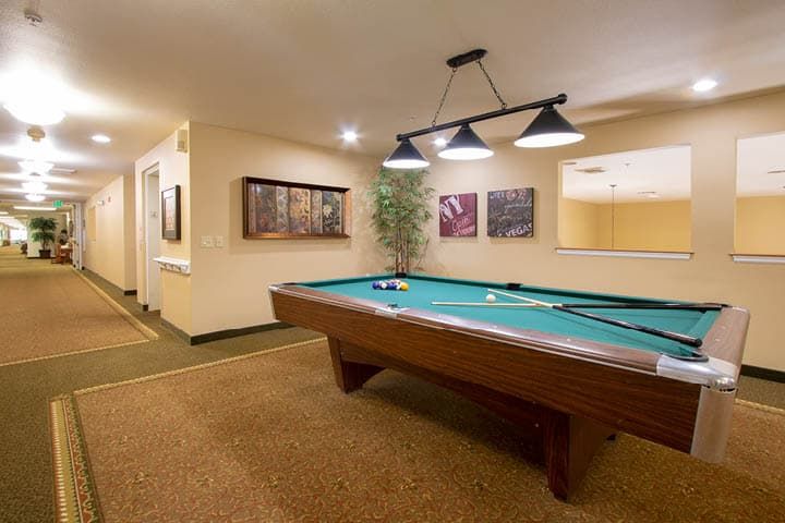 A cozy game room featuring a pool table and ambient lighting.