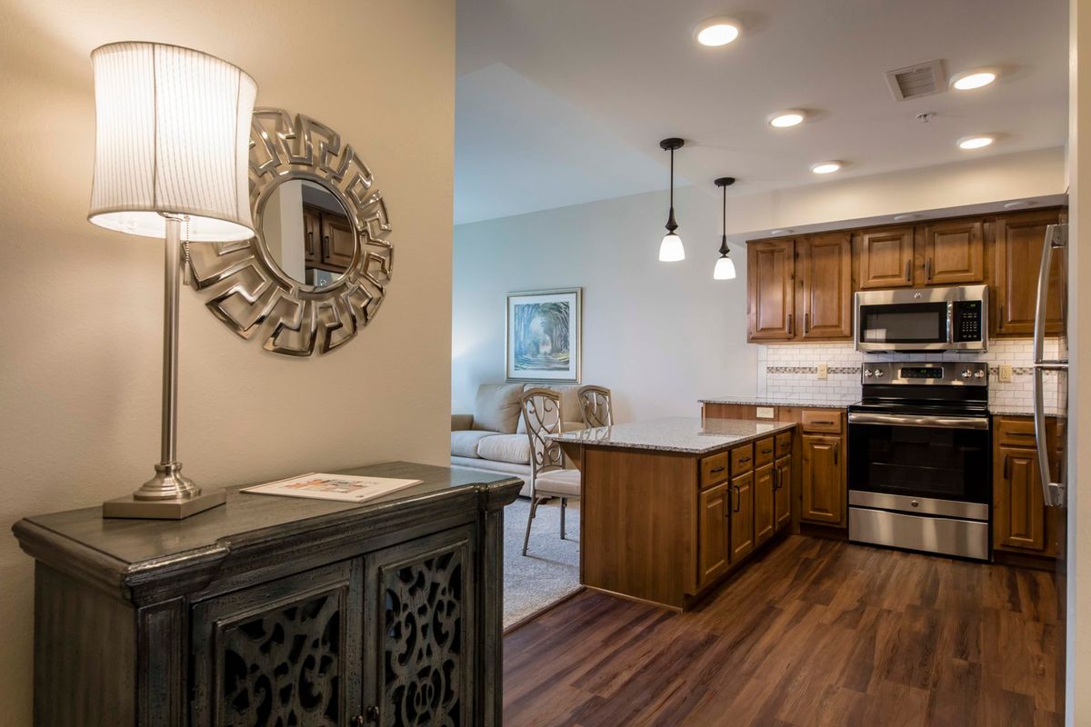 A cozy open-plan kitchen and dining area with modern lighting and elegant wooden elements.