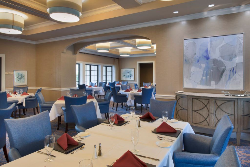 A stylish and elegant restaurant dining area with neatly arranged tables and chairs.