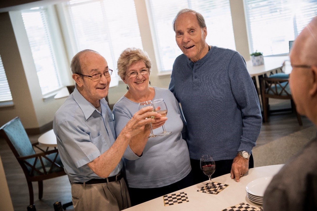 Three seniors enjoying a celebratory toast together.