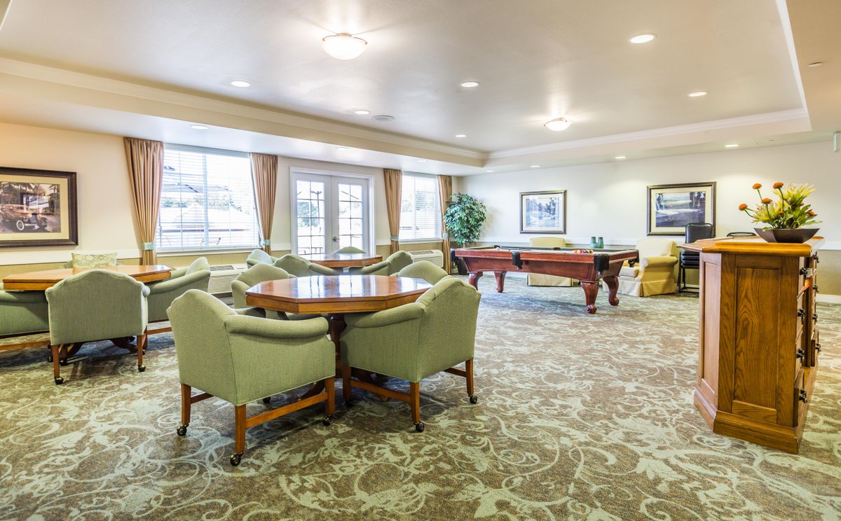 A spacious lounge area with comfortable seating and a billiards table.