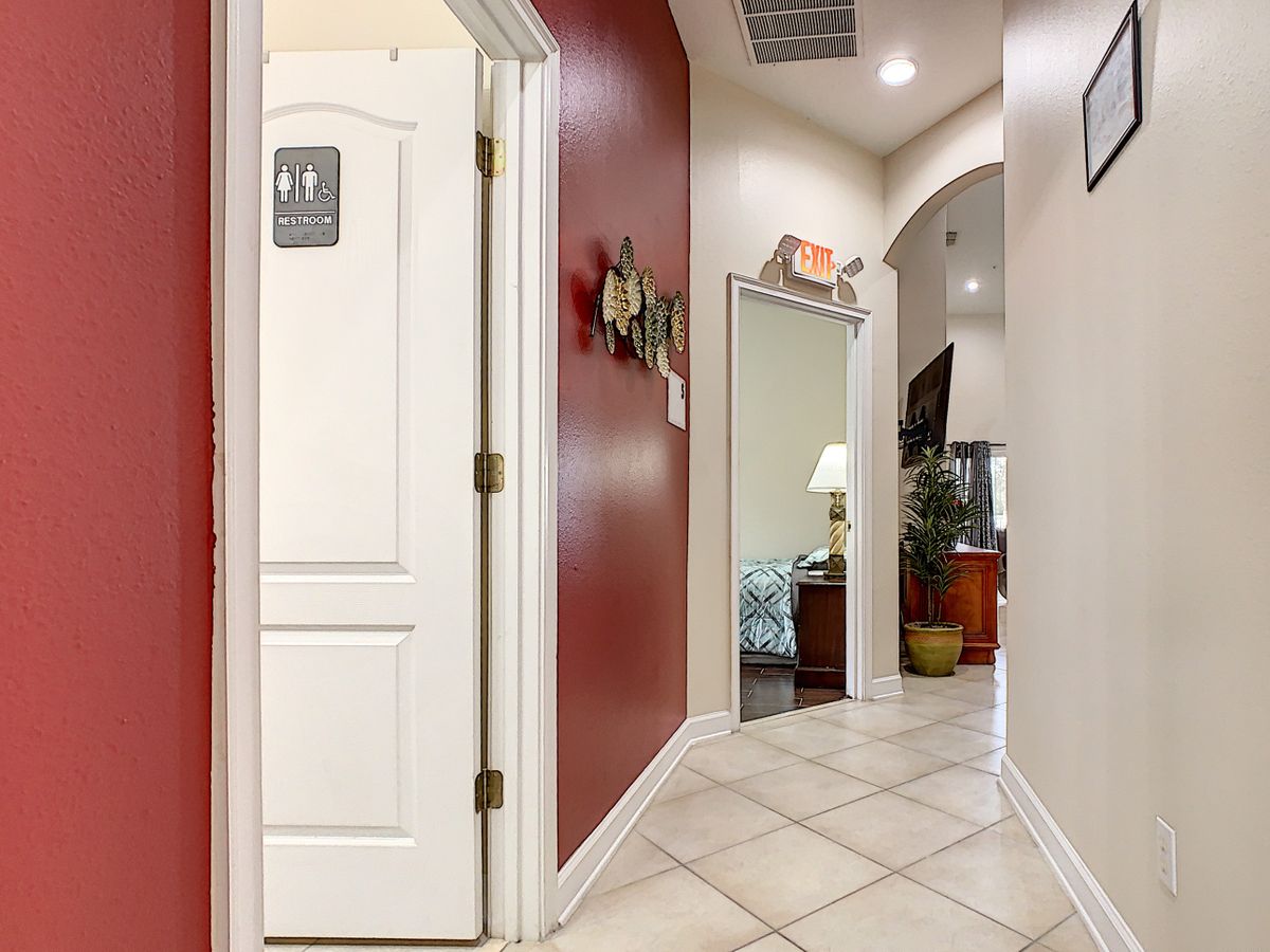 A well-lit hallway with a restroom door in an office setting.