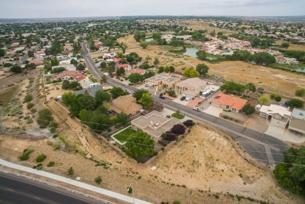 Aerial view of a suburban neighborhood with houses and dry terrain.