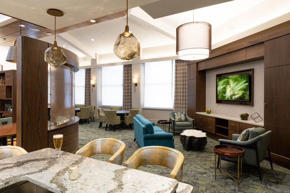 A modern lounge area featuring comfortable seating, stylish lighting, and a television.