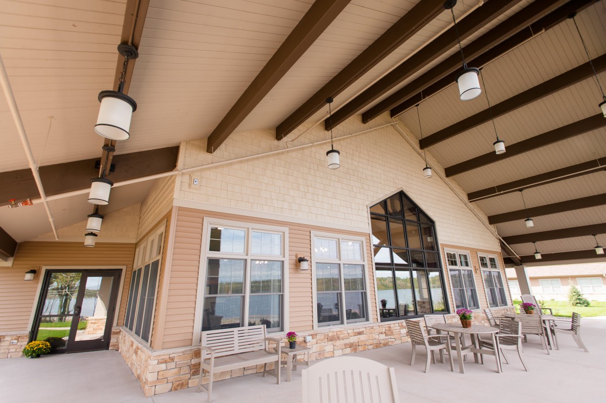 A modern patio area with seating and exposed wooden beams.