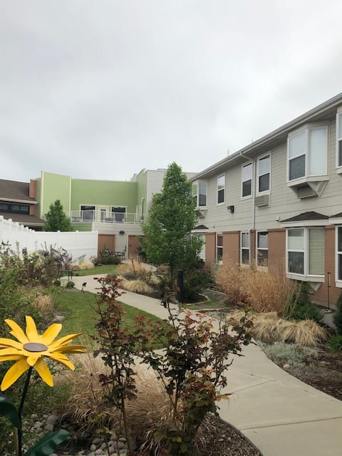 A residential apartment complex with a landscaped courtyard and garden path.