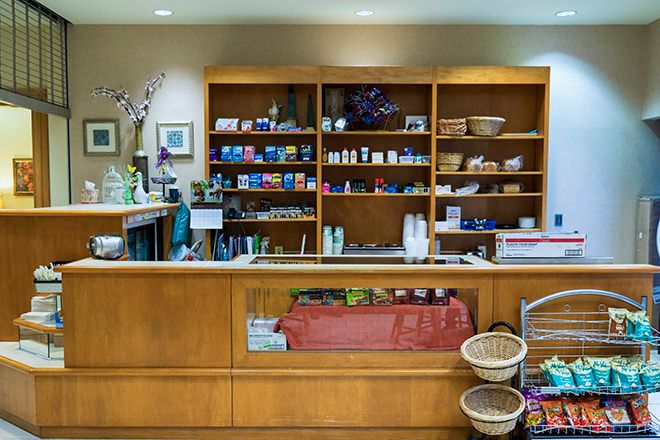 A retail counter with shelves stocked with various products.
