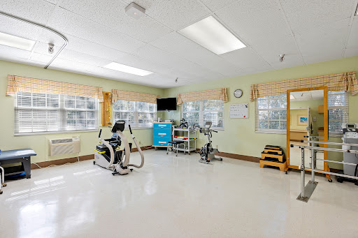 A well-lit rehabilitation room featuring various exercise machines and a clean, spacious layout.