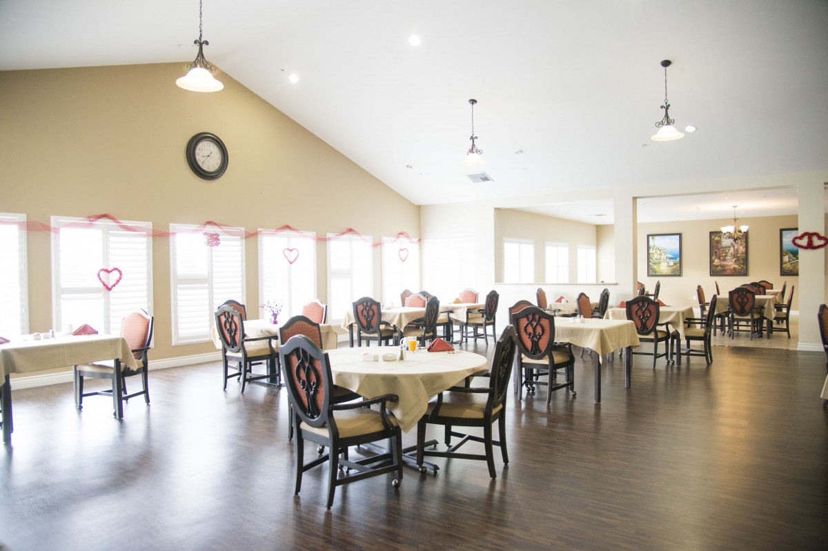 A bright and spacious dining room with elegantly set tables and chairs.