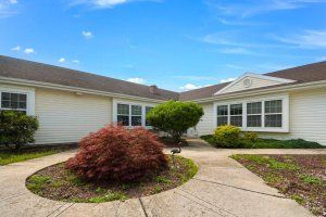 A single-story house with landscaped front yard and walkway.