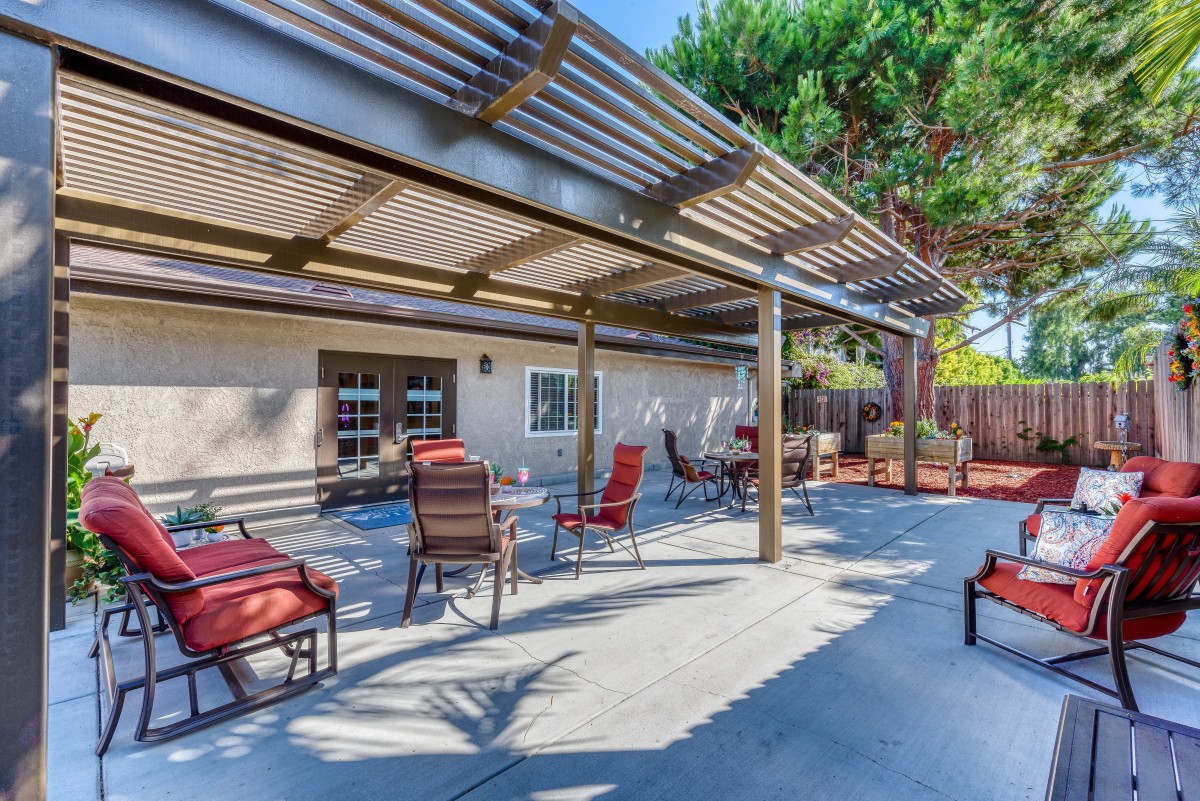 A spacious outdoor patio with seating under a pergola.