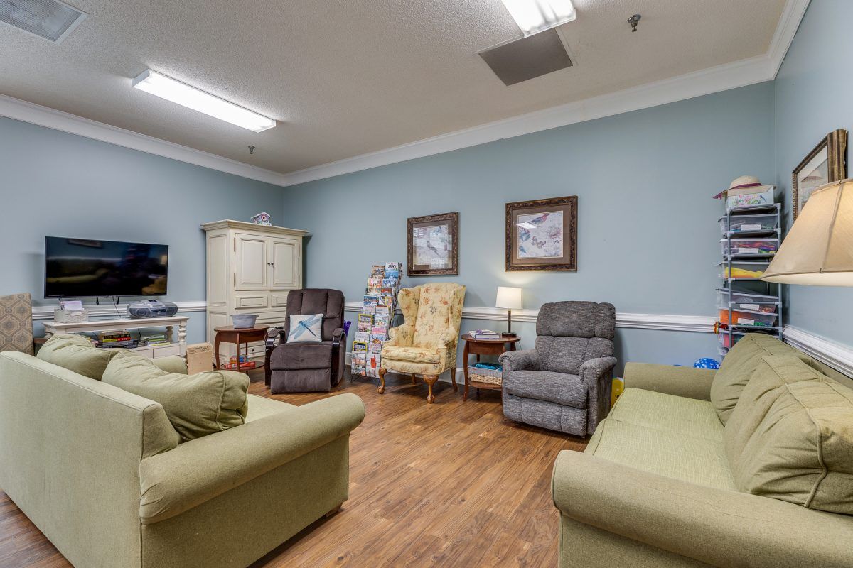 A cozy living room with various chairs and sofas arranged around a wooden floor.