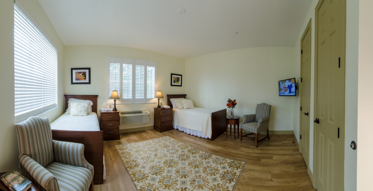 A spacious bedroom with twin beds, featuring cozy decor and ample natural light.