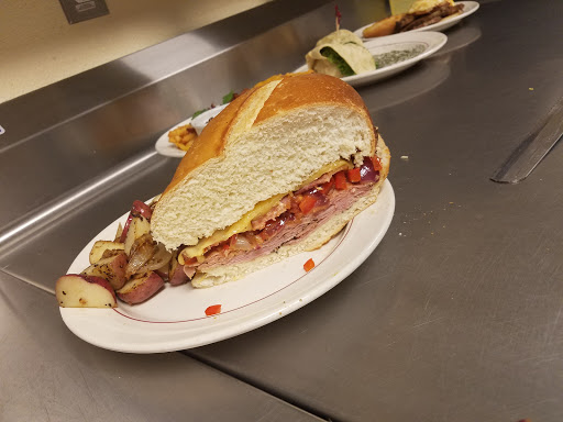 A delicious sandwich loaded with meats and toppings, served on a plate.