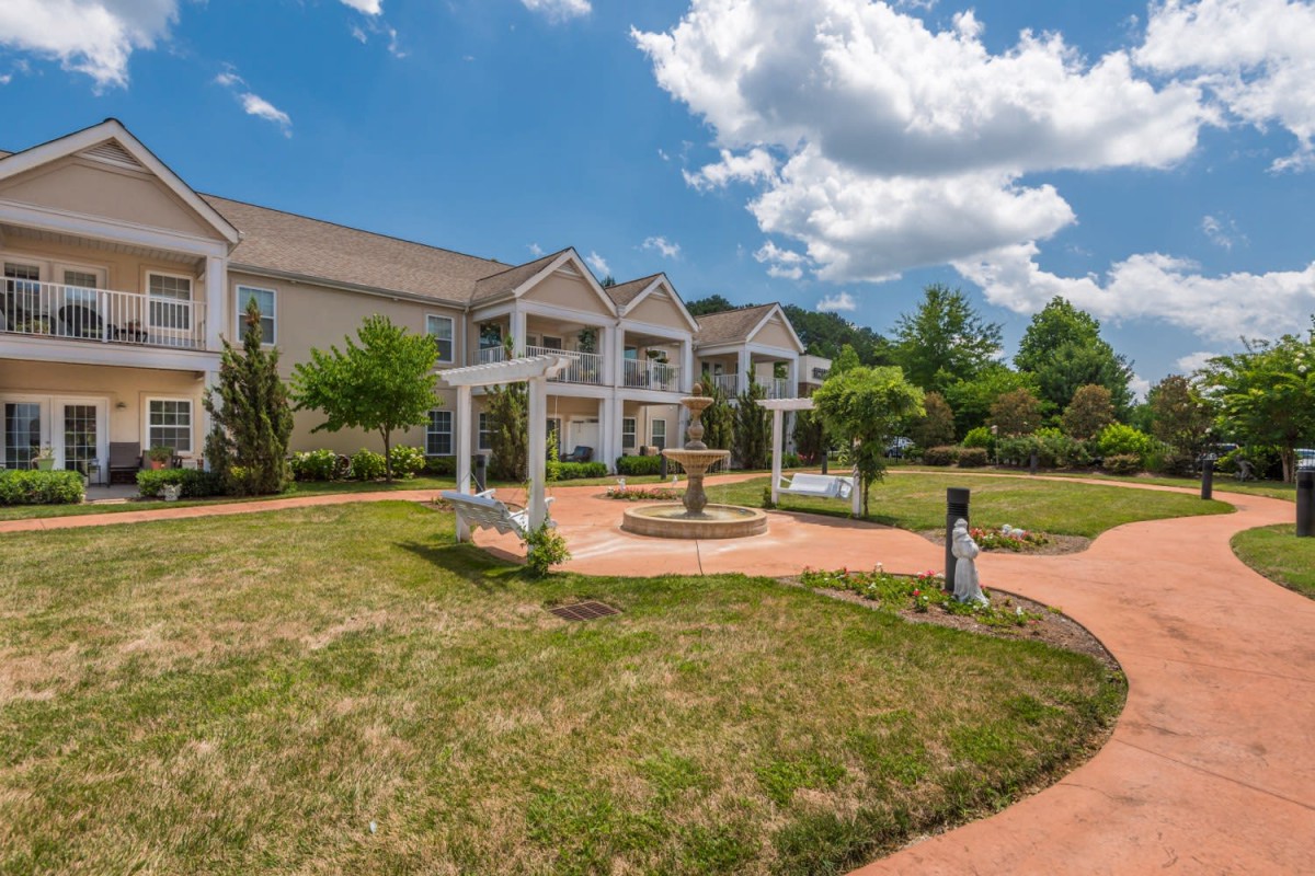 A scenic view of a building with a well-maintained garden and blue sky.