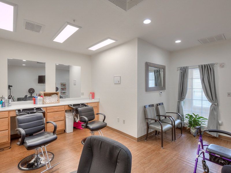A stylish and well-lit salon interior with seating areas for hair styling and a waiting section.