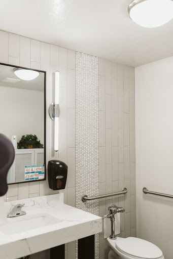 A modern bathroom featuring a sleek sink, mirror, and efficient lighting.