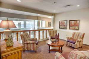 A cozy living room area featuring comfortable armchairs, a wooden coffee table, and decorative artwork on the walls.