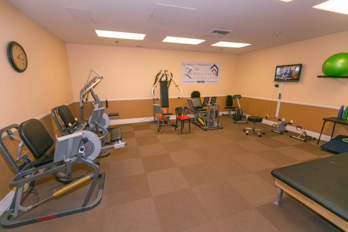 A gym with various exercise equipment, featuring a spacious workout area.