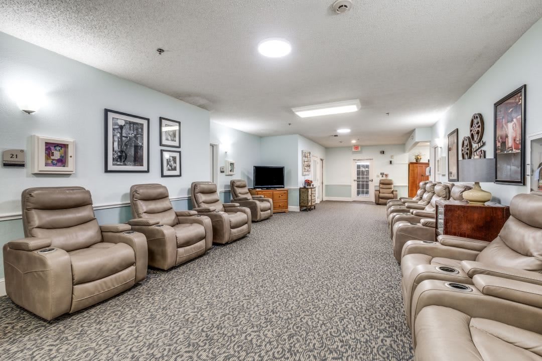 A spacious waiting room with comfortable chairs and a television.