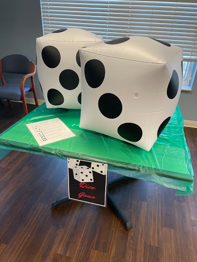 Giant inflatable dice on a green game table.